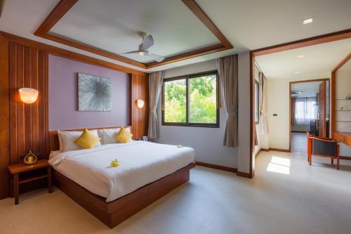 1 dormitorio con 1 cama grande con almohadas amarillas en Penthouse Savoye, en Ao Nang Beach