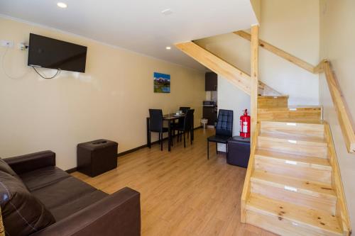 a living room with a couch and a staircase at Apartamentos Entre Fronteras in Punta Arenas