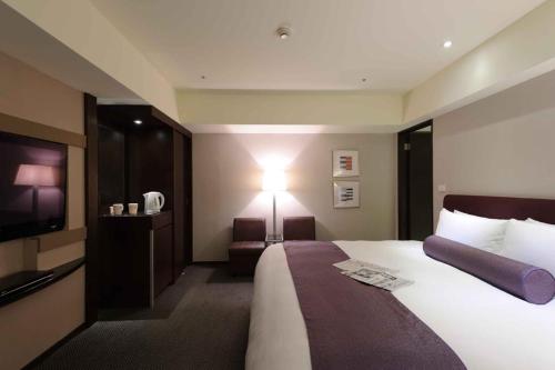 a hotel room with a bed and a television at K Hotel - Yunghe in Yonghe