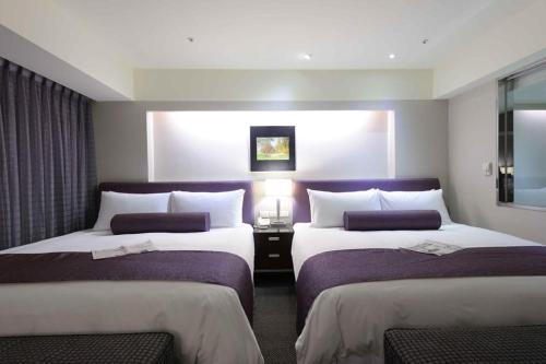 a hotel room with two beds and a window at K Hotel - Yunghe in Yonghe