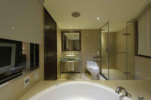 a bathroom with a tub and a toilet and a sink at K Hotel - Yunghe in Yonghe