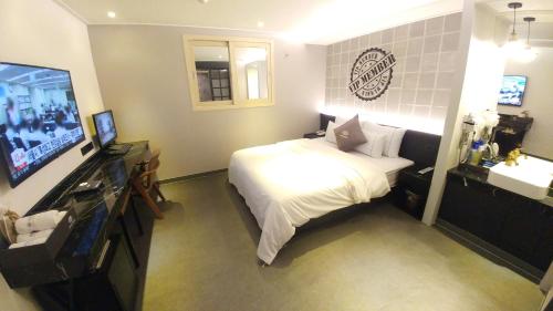 a bedroom with a bed and a flat screen tv at Vovo Hotel in Seosan