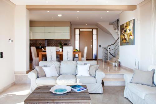 a living room with a white couch and a table at Alivia Lefkas Luxury Villas in Apolpaina