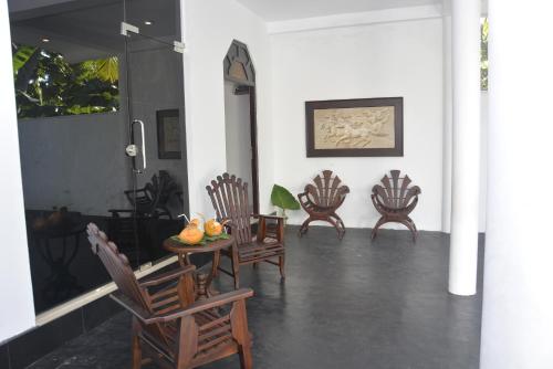 a room with chairs and a table with fruit on it at Star Nodes Villa in Galle