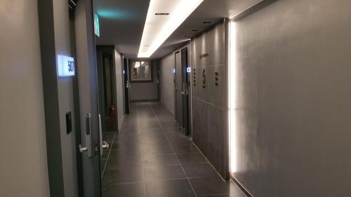 a corridor of a hallway with doors and a tile floor at Vovo Hotel in Seosan