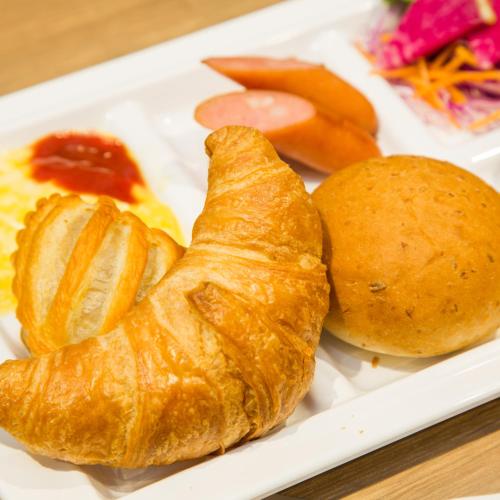 a plate of food with croissants and other foods at Super Hotel Premier Hakataeki in Fukuoka