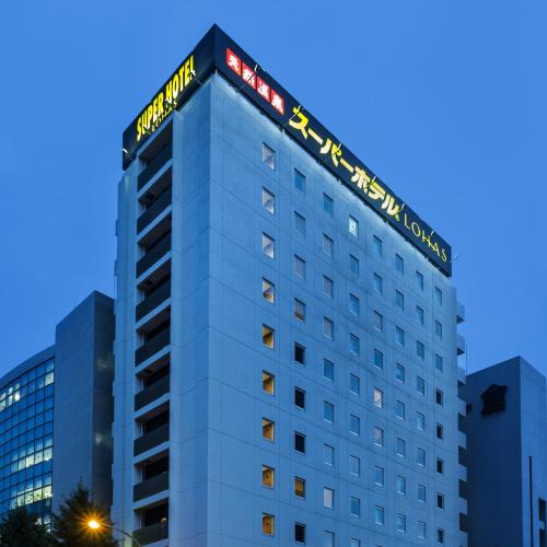 a building with a hotel sign on top of it at Super Hotel Premier Hakataeki in Fukuoka