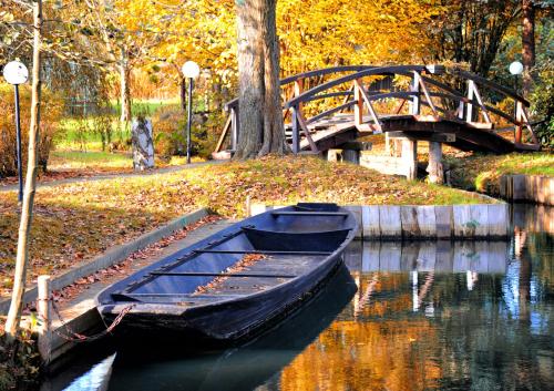 a boat sitting in the water near a bridge at Hotelanlage Starick in Lübbenau