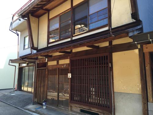 a building with a gate and windows on it at Yanaka no Taisuke in Gujo