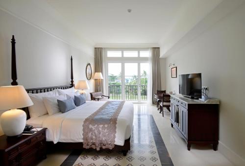 a bedroom with a large bed and a television at Rumah Luwih Bali in Keramas