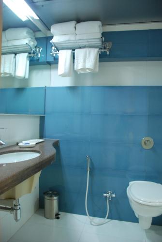 a bathroom with a toilet and a sink and towels at The Oriental Residency in Mumbai