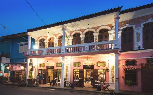 a group of buildings on a street at night at 2ROOMS Boutique House in Phuket