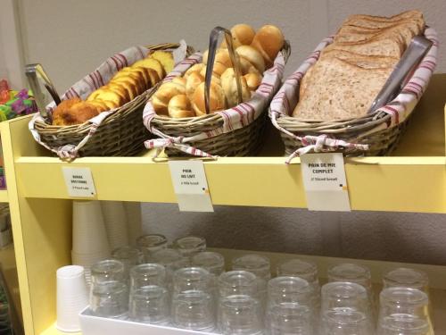 a shelf with baskets of bread and glasses of water at Premiere Classe Tours Sud - Chambray Lès Tours in Chambray-lès-Tours