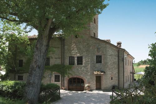 a large stone building with a tree in front of it at Monsignor Della Casa Country Resort & Spa in Borgo San Lorenzo