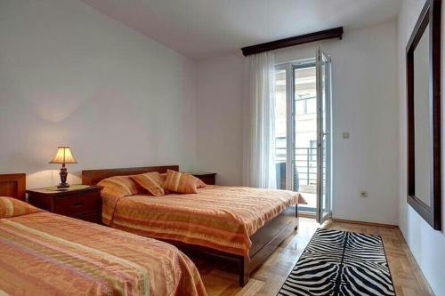 a hotel room with two beds and a window at Maestral Apartment in Petrovac in Petrovac na Moru