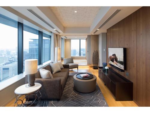 a living room with a couch and a tv at Ascott Marunouchi Tokyo in Tokyo