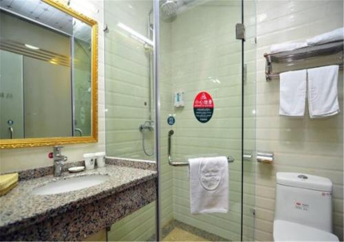 ein Badezimmer mit einem Waschbecken, einem WC und einem Spiegel in der Unterkunft GreenTree Inn Yunnan Kunming Chenggong University City Shilin Street Express Hotel in Kunming