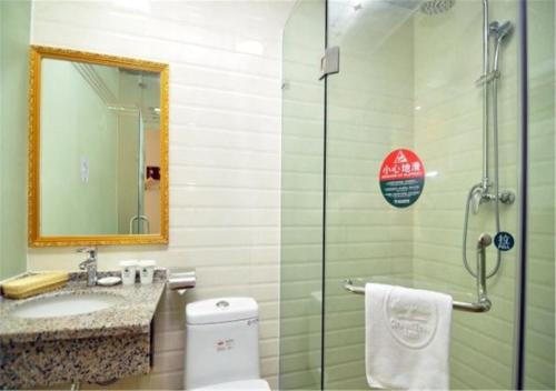 a bathroom with a shower and a toilet and a sink at GreenTree Inn Yunnan Kunming Chenggong University City Shilin Street Express Hotel in Kunming