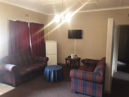 a living room with two couches and a tv at Horseshoe Inn and Conference Center in Kimberley