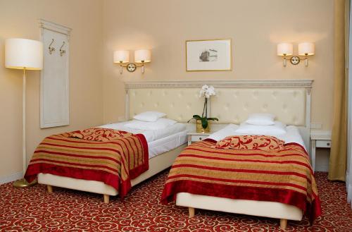 two beds sitting next to each other in a room at Hotel Royal Baltic 4* Luxury Boutique in Ustka