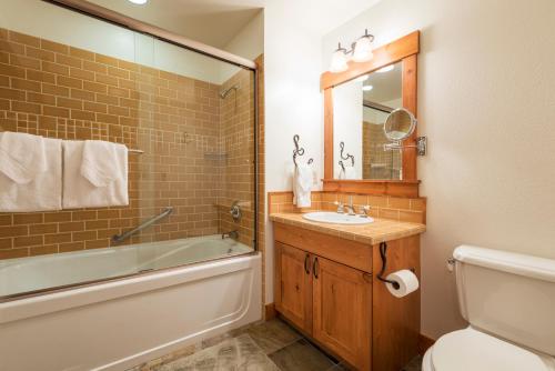 y baño con lavabo, bañera y aseo. en Cabins 13, en Old Mammoth