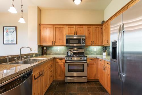 a kitchen with wooden cabinets and stainless steel appliances at Cabins 21 in Old Mammoth