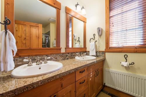 a bathroom with two sinks and two mirrors at Cabins 21 in Old Mammoth