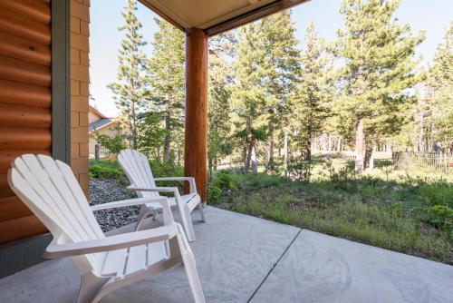two white chairs sitting on the porch of a house at Cabins 13 in Old Mammoth