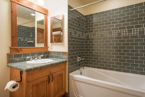 a bathroom with a tub and a sink and a bath tubermottermott at Cabins 21 in Old Mammoth