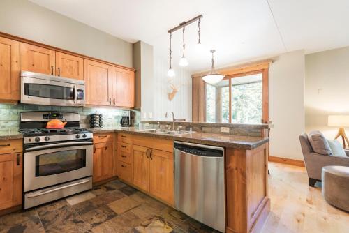 a kitchen with wooden cabinets and stainless steel appliances at Cabins 13 in Old Mammoth