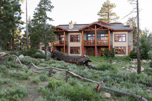 a house with a log in front of it at Cabins 21 in Old Mammoth