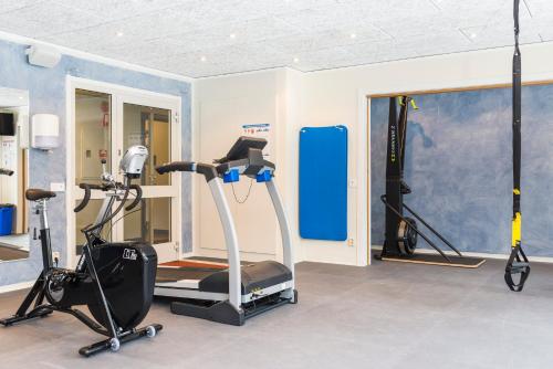 a gym with two exercise bikes and a treadmill at First Camp Moraparken - Dalarna in Mora