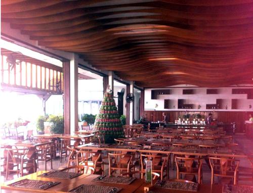 a restaurant with wooden tables and a christmas tree in the middle at The Cliff Residence in Mui Ne