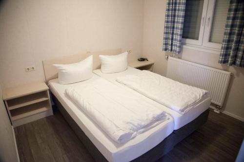 a bedroom with a bed with white sheets and pillows at M13 Hotel in Riol