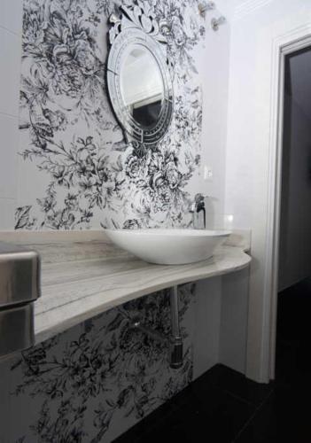 a bathroom with a sink and a mirror on a wall at Hospedería el Puerto in Colindres