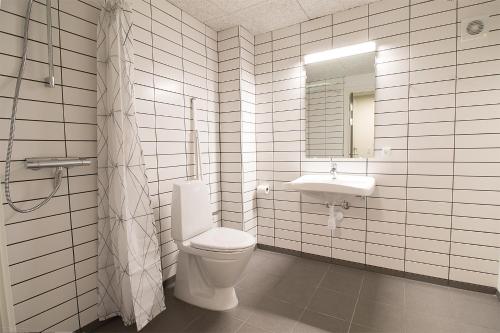 a bathroom with a toilet and a sink at Hostel Brønderslev in Brønderslev
