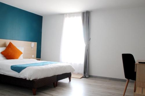 a bedroom with a bed and a large window at Saglam Hôtel in Goussainville