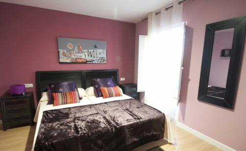 a bedroom with a large bed with purple walls at Hospedería el Puerto in Colindres
