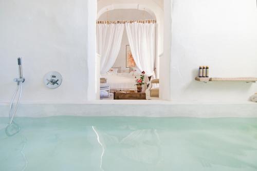 a white room with a pool of water at Masseria Le Torri in Polignano a Mare