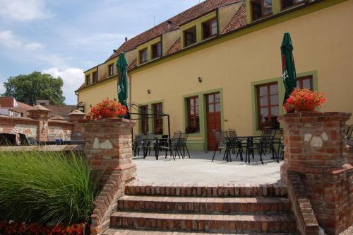 a patio with tables and chairs in front of a building at Hotel Aurelius Mikulov in Mikulov