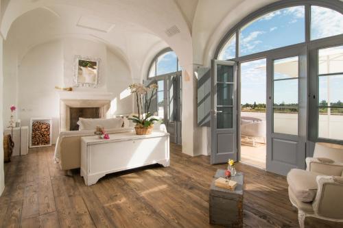 a white bedroom with a bed and a fireplace at Masseria Le Torri in Polignano a Mare