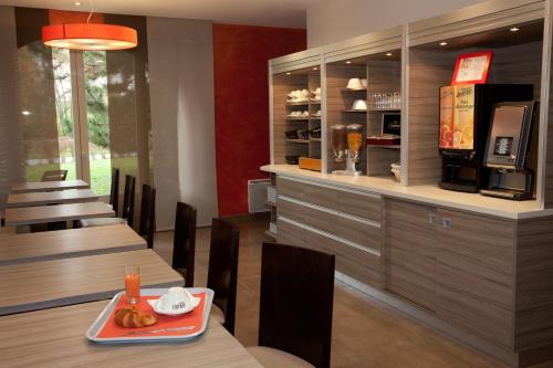 ein Restaurant mit zwei Tischen und einer Theke mit einem Café in der Unterkunft Logis Albhotel Grill in Alby