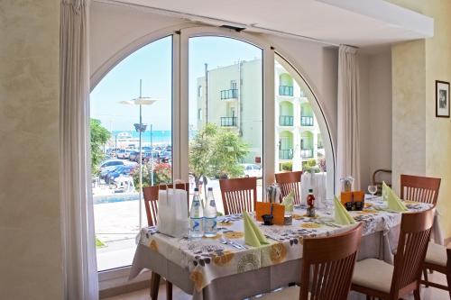 a dining room with a table and a large window at Hotel Europa in Misano Adriatico