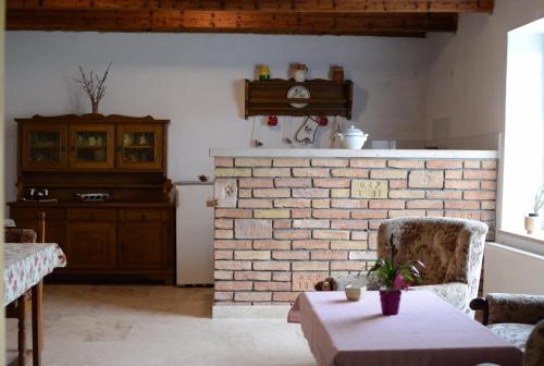 a living room with a brick fireplace and a table at Gerecse Vendégház in Süttő