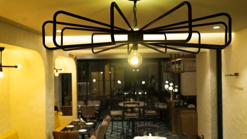 a chandelier in a restaurant with tables and chairs at Hotel Harbour View Colaba in Mumbai