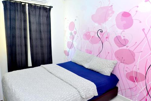 a bedroom with a bed with a pink flower wall at branded hotel in Malacca