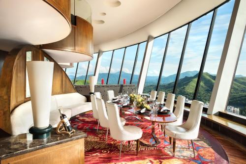 a dining room with a table and chairs and windows at Shangri-La Shenzhen - Nearby Luohu Border, Outdoor Swimming Pool in Shenzhen