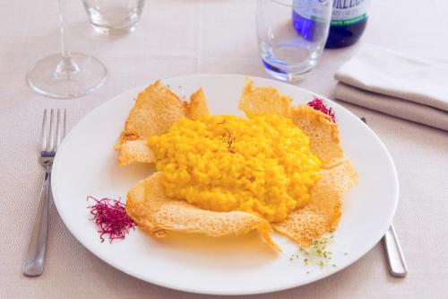 a white plate of food on a table at eco Hotel Milano & BioRiso Restaurant in Milan