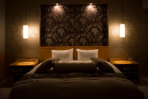 a bedroom with a large bed with two night stands at Hachinohe Park Hotel in Hachinohe