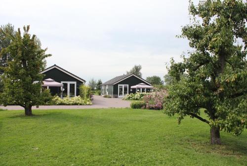 a couple of houses in a yard with trees at Fruitbedrijf Stek in Kedichem